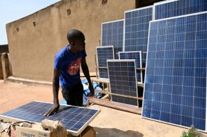 A shopkeeper stores solar panels in a street in Ouagadougou on September 23, 2019. - The solar panel market has exploded in recent years in Burkina as heads of state of the G5 Sahel supported an initiative called 